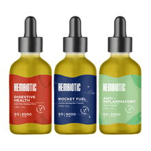 Load image into Gallery viewer, Three dropper bottles of Hembiotic 5000mg Bulk CBD Oil - 50ml are aligned side by side. The first bottle is labeled &quot;Digestive Health&quot; with a red design. The second, &quot;Rocket Fuel,&quot; showcases a blue design. The third, &quot;Anti-Inflammatory,&quot; features a green design. Each vegan-friendly bottle contains lab-tested CBD oil from the Hembiotic brand.
